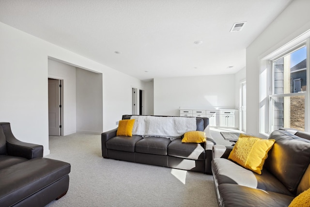 living area featuring visible vents, baseboards, and carpet floors