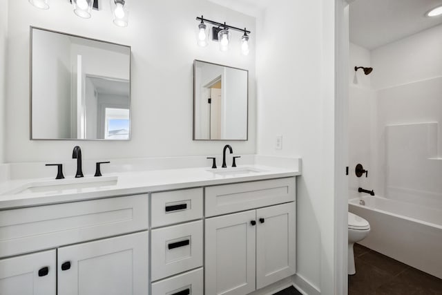 full bath with a sink, toilet, double vanity, and tile patterned flooring