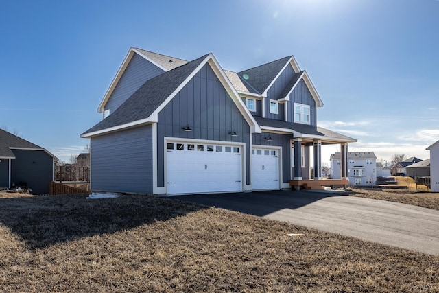 view of front of home with a garage, board and batten siding, driveway, and roof with shingles