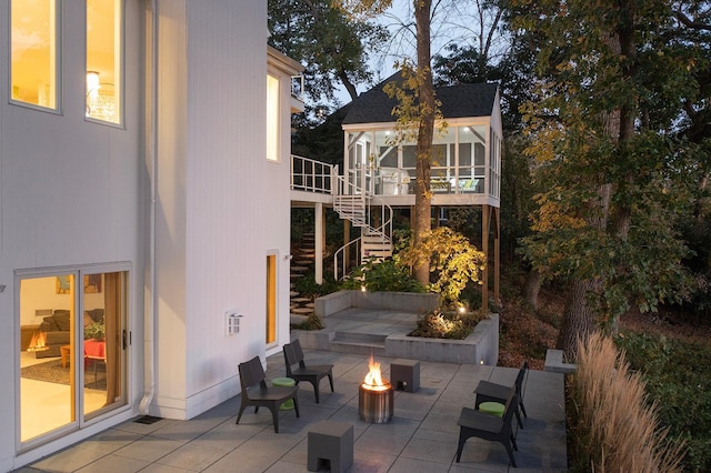 view of patio with stairway, a wooden deck, and an outdoor fire pit