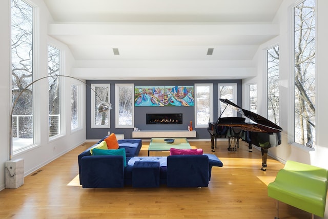 sunroom / solarium featuring a glass covered fireplace, vaulted ceiling, and visible vents