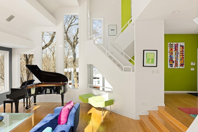 living area featuring stairway, visible vents, baseboards, and wood finished floors