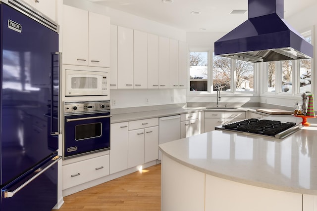 kitchen featuring ventilation hood, white microwave, a sink, oven, and high end black refrigerator