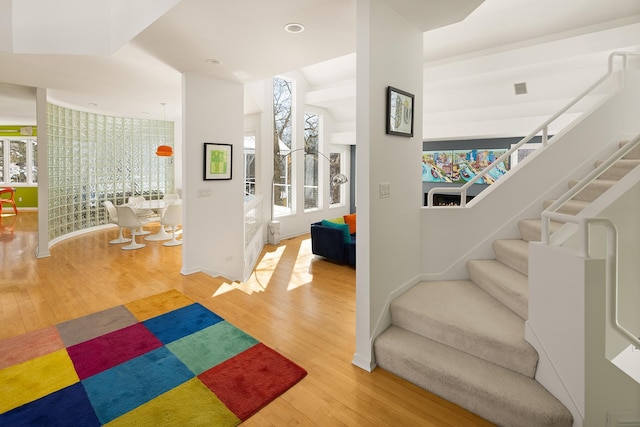 foyer entrance featuring a wealth of natural light, stairway, recessed lighting, and hardwood / wood-style flooring