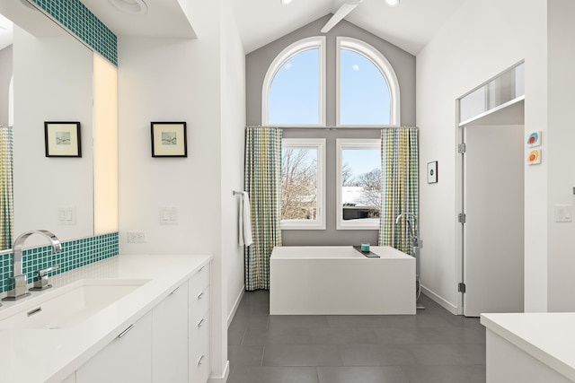 full bathroom featuring high vaulted ceiling, baseboards, a soaking tub, and vanity