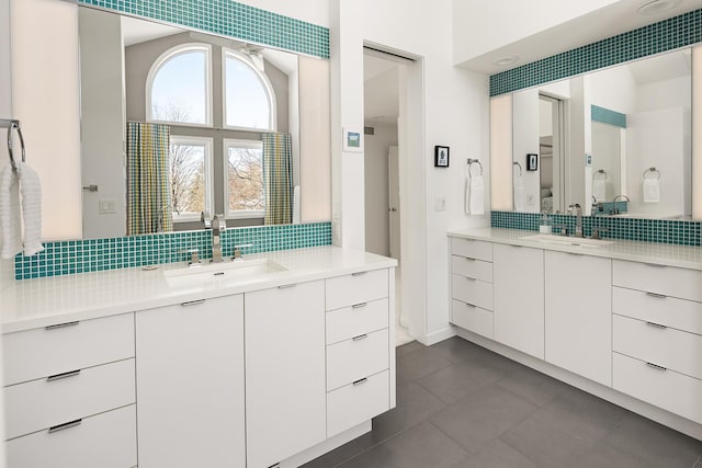 bathroom with a sink, decorative backsplash, and two vanities