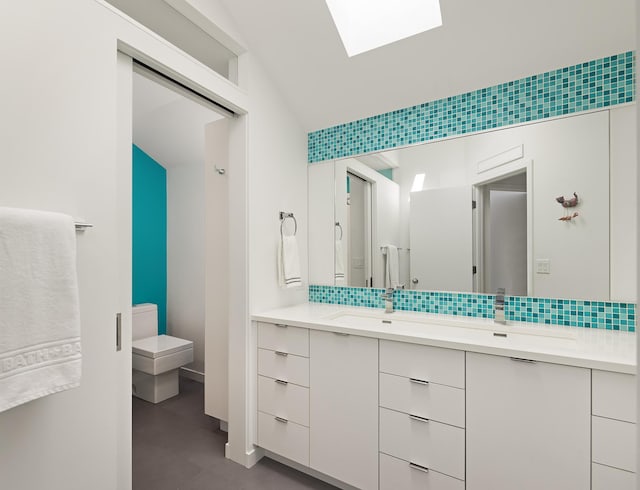 full bathroom featuring a skylight, decorative backsplash, toilet, and vanity