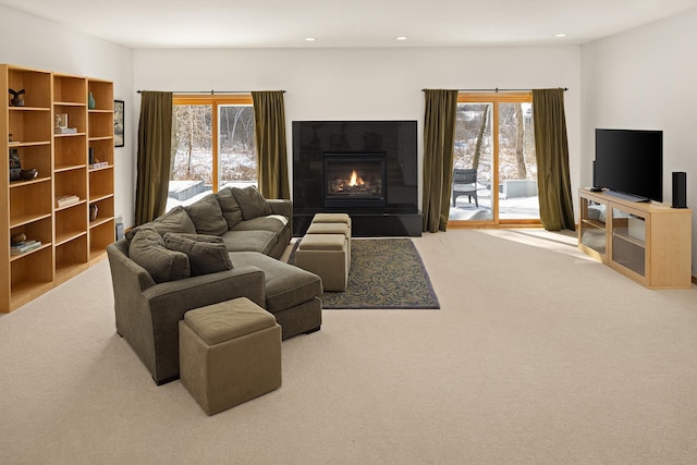 living area with a glass covered fireplace, recessed lighting, and a healthy amount of sunlight