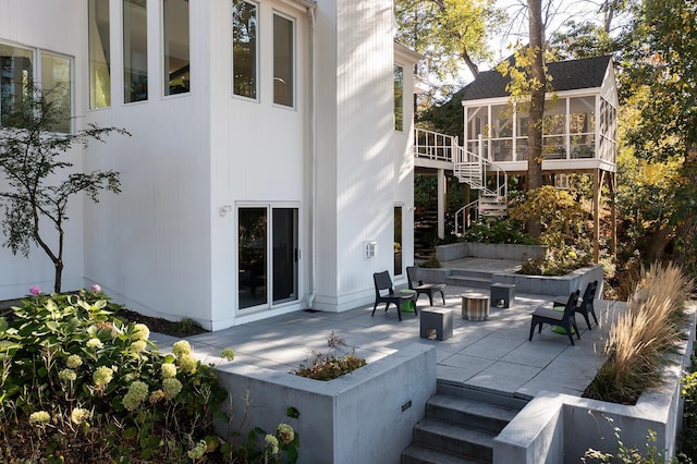 view of patio / terrace with stairs and a sunroom