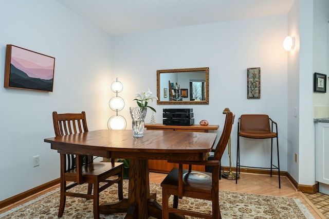 dining area featuring light wood-type flooring and baseboards