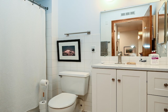 full bathroom featuring toilet, vanity, visible vents, tile walls, and a shower with curtain