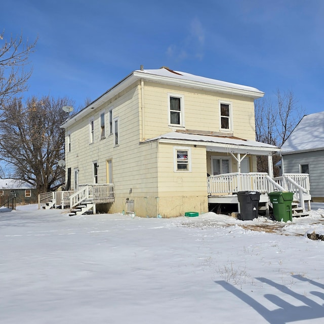 snow covered property featuring covered porch