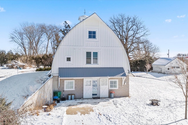 view of front of house featuring an outdoor fire pit, a barn, and a gambrel roof