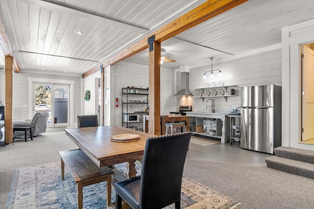 dining area featuring wood walls, wood ceiling, and beamed ceiling