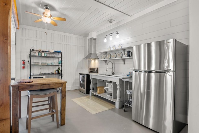 kitchen featuring finished concrete flooring, wall chimney exhaust hood, appliances with stainless steel finishes, and open shelves