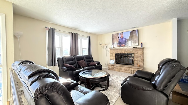 carpeted living room featuring a stone fireplace and a textured ceiling