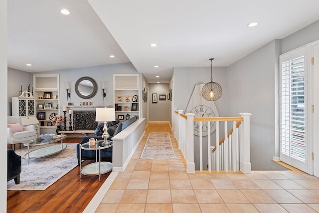 hallway featuring recessed lighting, an upstairs landing, and tile patterned floors