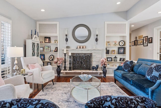 living room featuring lofted ceiling, a fireplace, wood finished floors, and recessed lighting