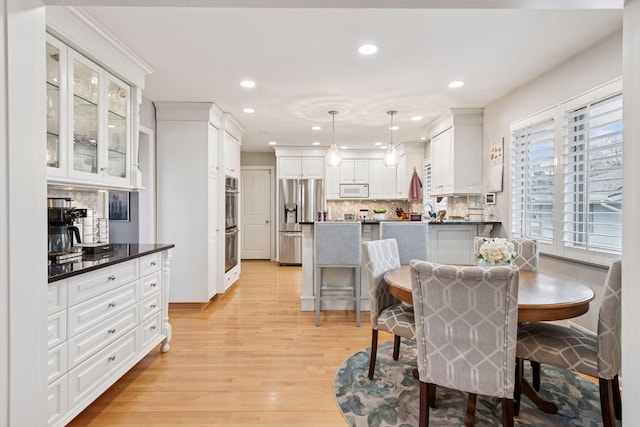 dining area with light wood-type flooring and recessed lighting