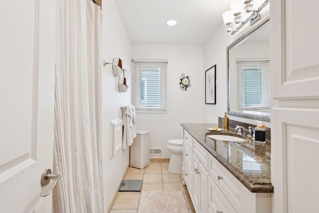 bathroom with visible vents, toilet, vanity, tile patterned flooring, and baseboards