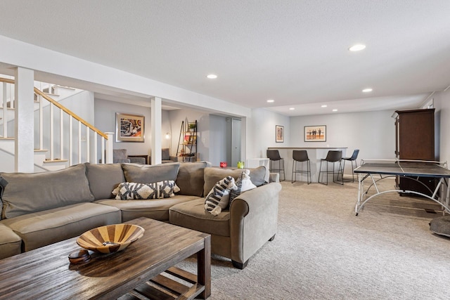 living room featuring recessed lighting, light colored carpet, a textured ceiling, a bar, and stairs