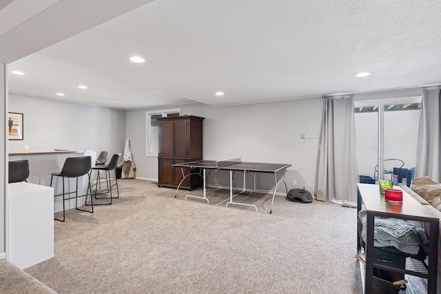 playroom with recessed lighting, light colored carpet, a textured ceiling, and baseboards