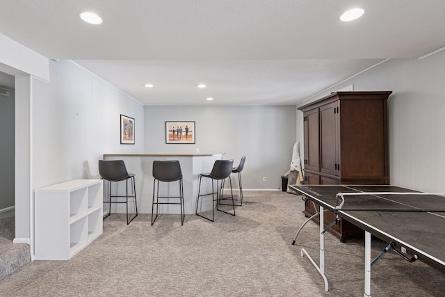 game room featuring recessed lighting, baseboards, light carpet, and a bar