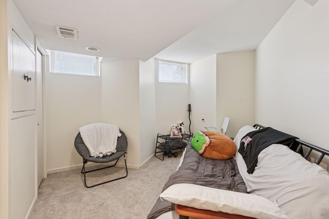 bedroom with visible vents, light carpet, and baseboards