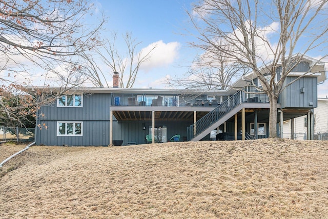 back of property with a chimney, stairway, fence, and a wooden deck