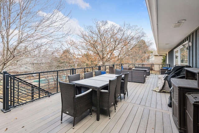 wooden terrace with outdoor dining area and an outdoor living space