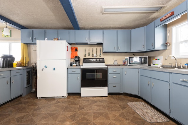 24932 Wall Lake Point Cir, Fergus Falls, MN 56537 - kitchen featuring white appliances, blue cabinets, light countertops, a textured ceiling, and a sink