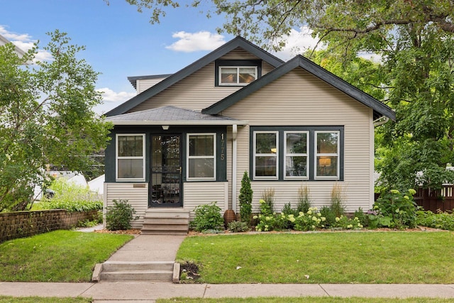 bungalow-style house featuring entry steps and a front yard