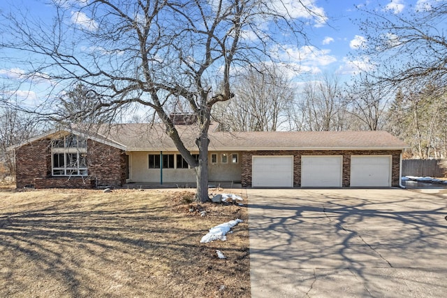 view of front of house with a garage, brick siding, concrete driveway, and stucco siding