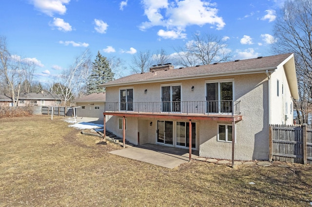 back of property with a patio area, stucco siding, a lawn, and fence