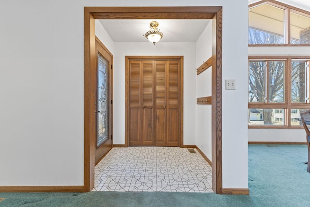 entryway with visible vents, baseboards, and light colored carpet