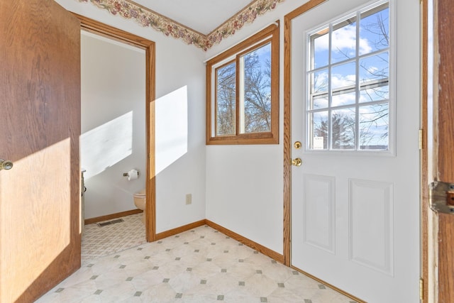 doorway to outside with visible vents, baseboards, and light floors