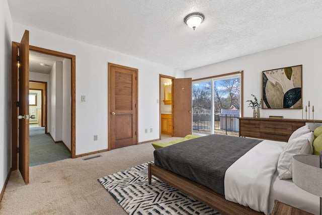 carpeted bedroom with access to outside, baseboards, visible vents, and a textured ceiling