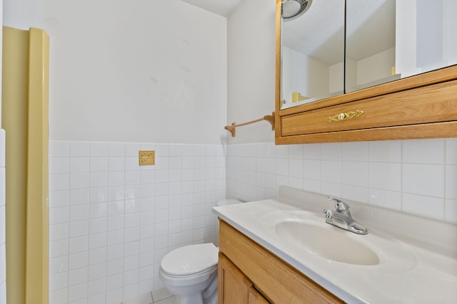 half bathroom with a wainscoted wall, toilet, tile walls, and vanity