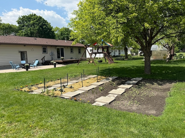 502 19th St N, Benson, MN 56215 - view of grassy yard featuring a playground, a patio, and a vegetable garden