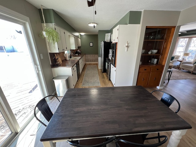 502 19th St N, Benson, MN 56215 - dining room featuring light wood-style floors, a textured ceiling, and a ceiling fan