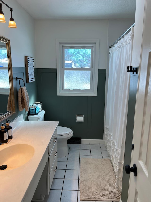 502 19th St N, Benson, MN 56215 - full bathroom featuring vanity, tile patterned flooring, toilet, healthy amount of natural light, and wainscoting