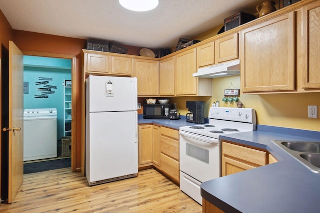 kitchen with white appliances, light brown cabinets, under cabinet range hood, and washer / dryer