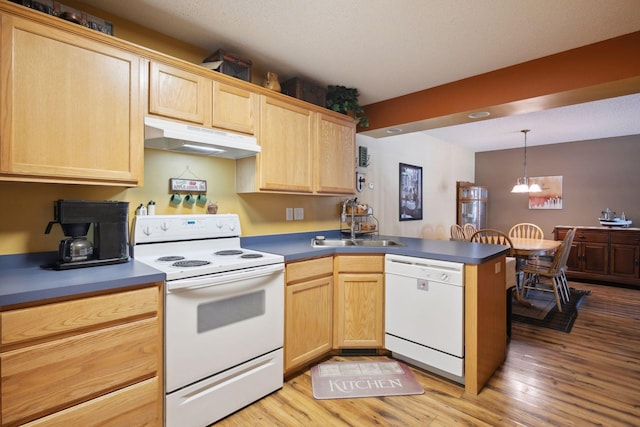 kitchen with decorative light fixtures, light wood-style flooring, a peninsula, white appliances, and under cabinet range hood