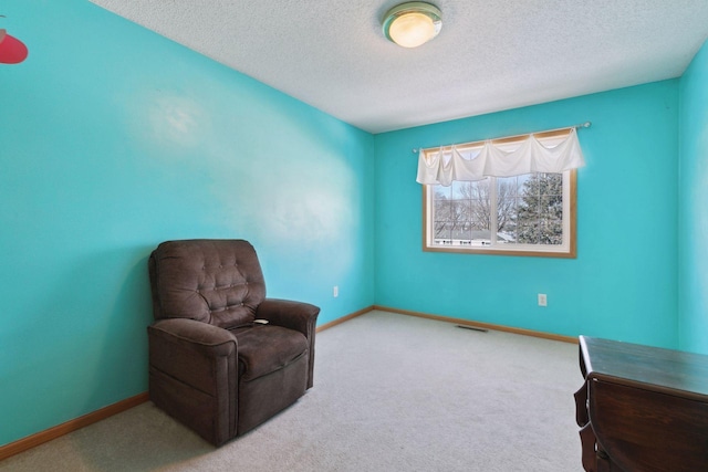 sitting room with carpet floors, baseboards, visible vents, and a textured ceiling