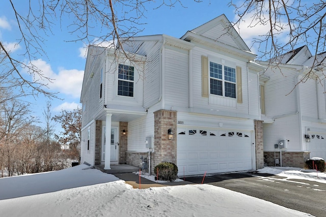 view of front of house featuring a garage, stone siding, and aphalt driveway