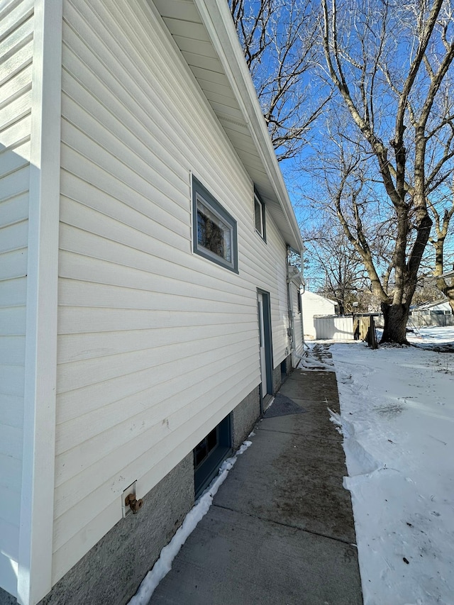 view of snowy exterior with fence