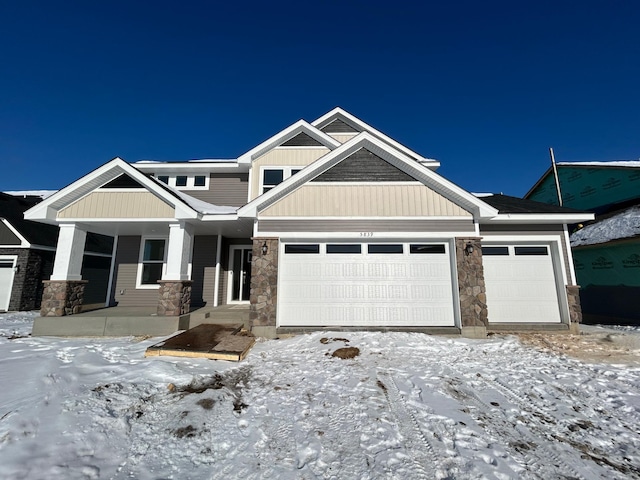 craftsman-style house featuring stone siding, board and batten siding, and an attached garage