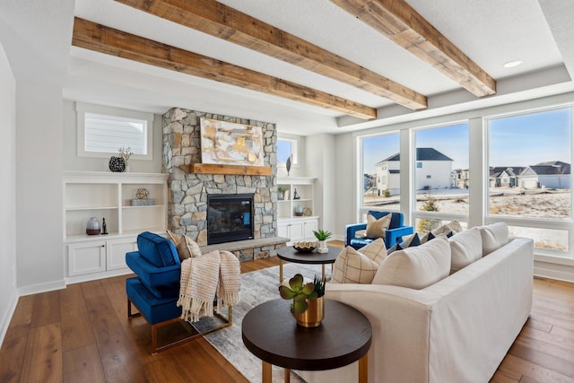 living room with a fireplace, baseboards, wood finished floors, and beamed ceiling