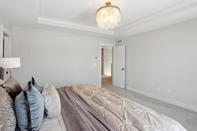 bedroom featuring light carpet, visible vents, baseboards, and a raised ceiling