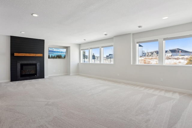 unfurnished living room featuring baseboards, a fireplace, and light colored carpet